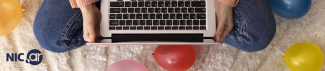 persona con una laptop sobre sus piernas y globos alrededor