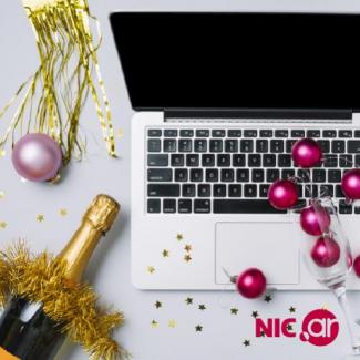 Laptop, botella de champagne y adornos festivos de Año Nuevo